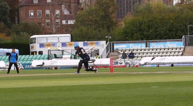 Picture of Worcester New Road cricket ground, with a cricket player batting in the foreground and the Cathedral in the background.