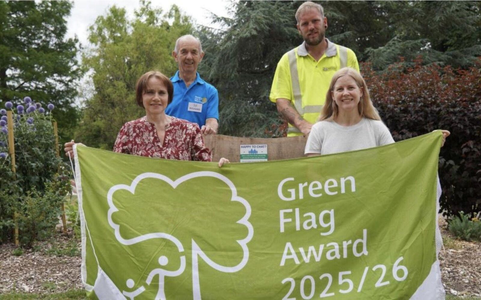 Zoe Cookson with one other adult and two children holding a banner saying Green Flag award 2025/26