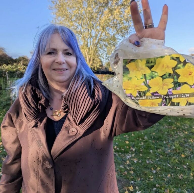 Jill Desayrah holding a bag of daffodil bulbs during a community planting project in Warndon